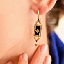 Load image into Gallery viewer, Boucles d'oreilles Ava or jaune, émail noir, diamants noirs et champagne, saphirs jaunes portées
